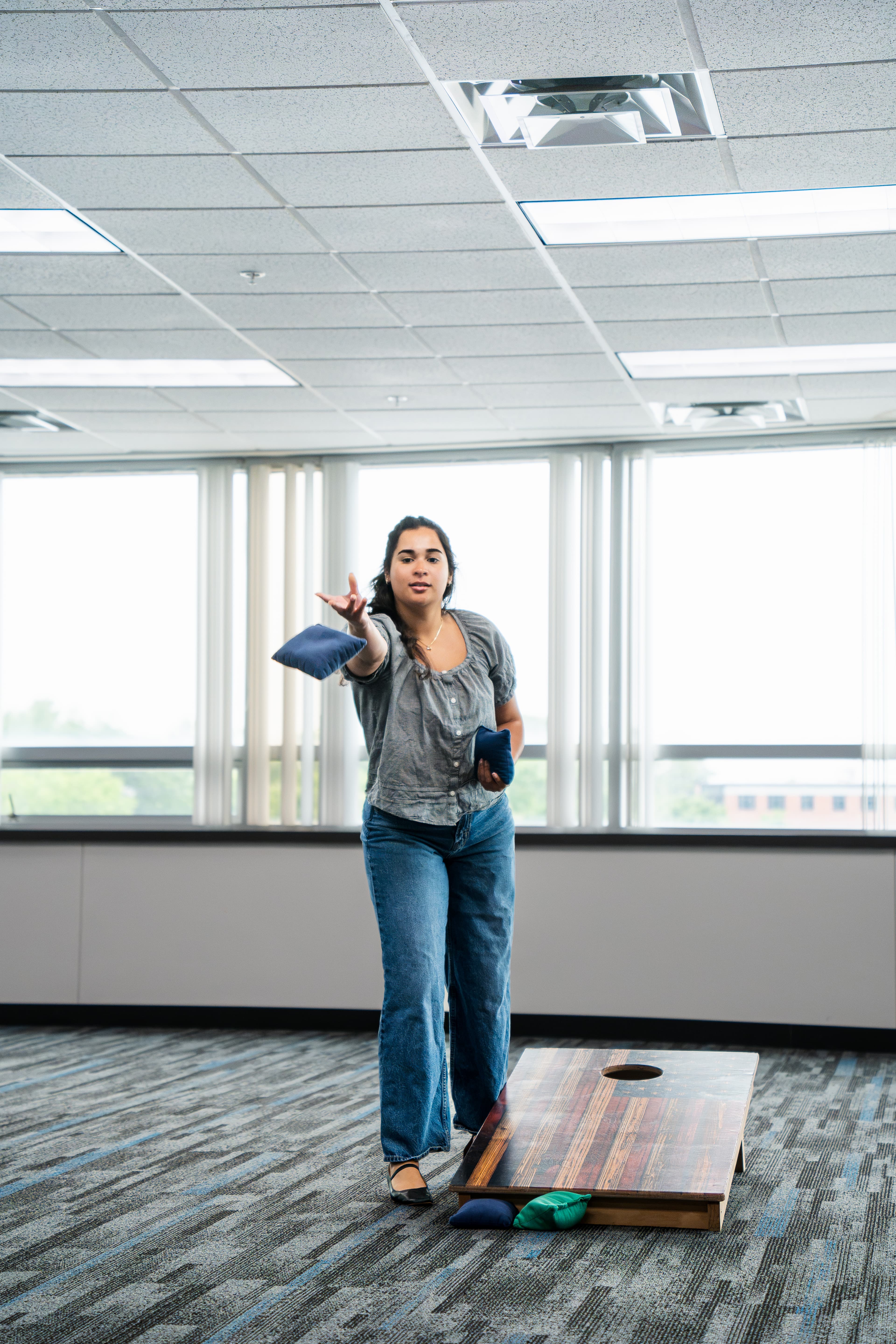 A Vi-Leon team member playing cornhole in the office